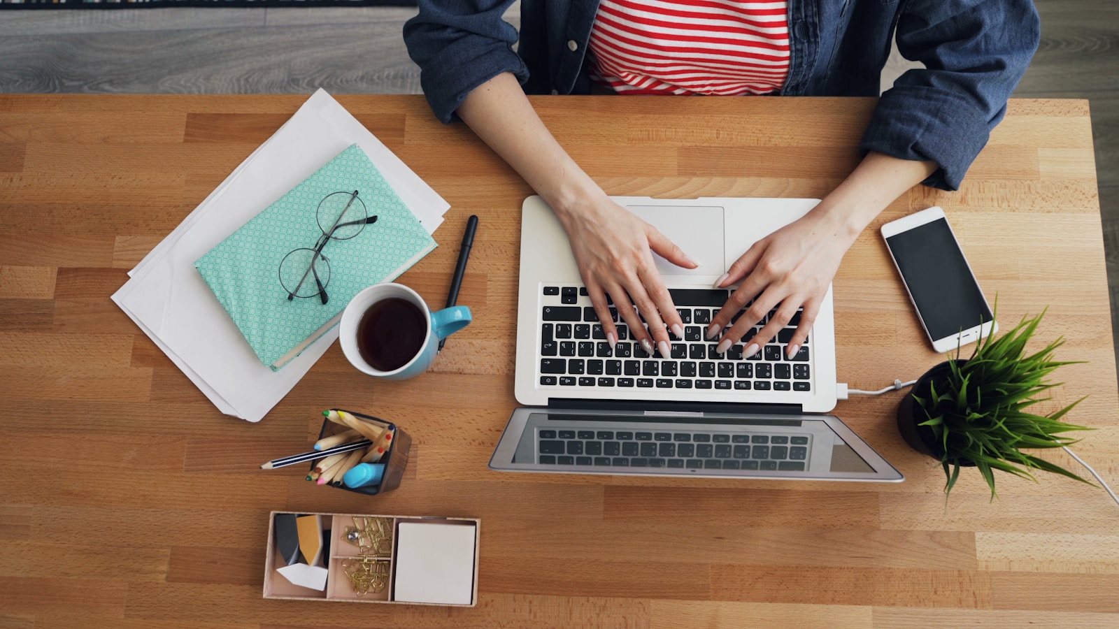 a woman sitting at a table working on a laptop